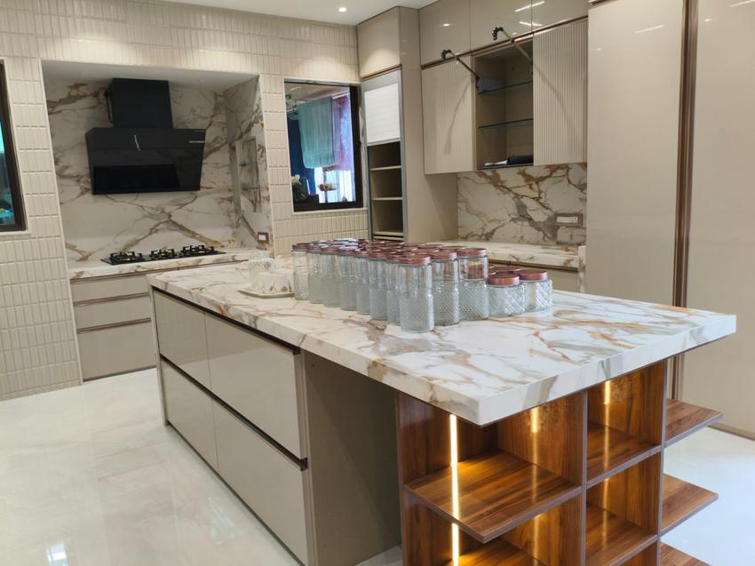 Modern kitchen with marble island counter styled with glass jars, walnut lit shelving