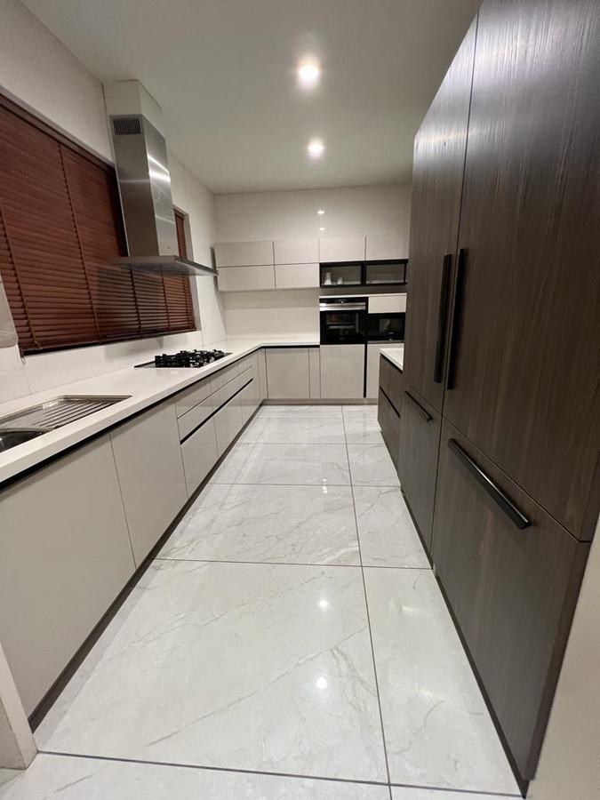 White galley kitchen with dark wood tall units and steel chimney