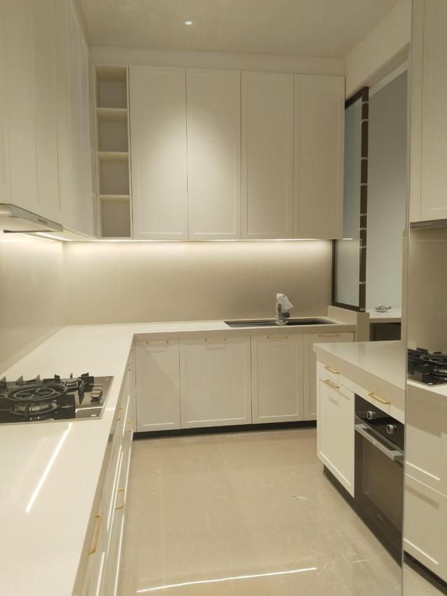 White shaker-style kitchen with brass handles and LED under-cabinet lighting