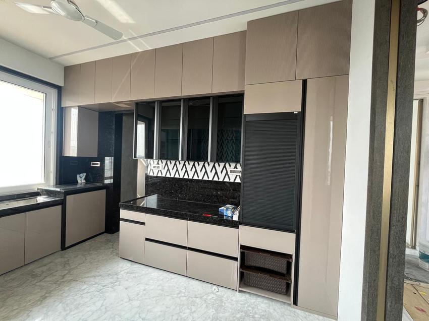Beige gloss kitchen with black granite counters and chevron backsplash