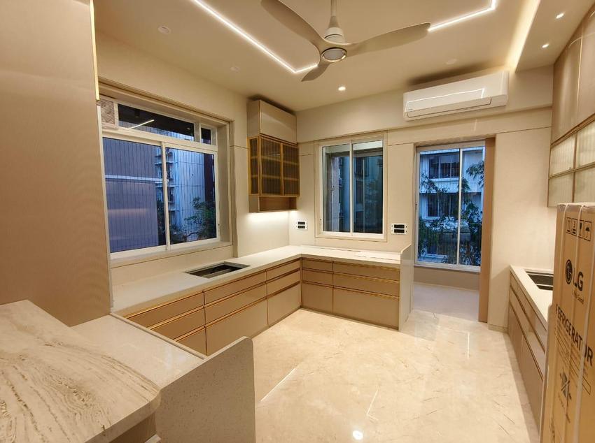Beige and gold-trimmed kitchen with marble breakfast counter and L-shape layout