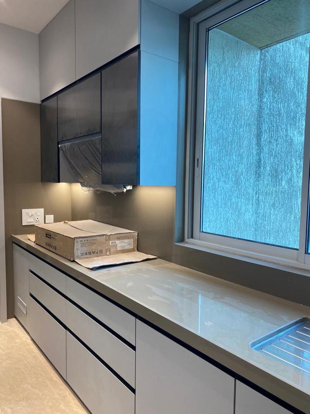 White and grey kitchen with fluted upper cabinets during installation