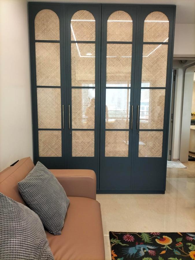 Navy blue wardrobe with arched cane panels in living space