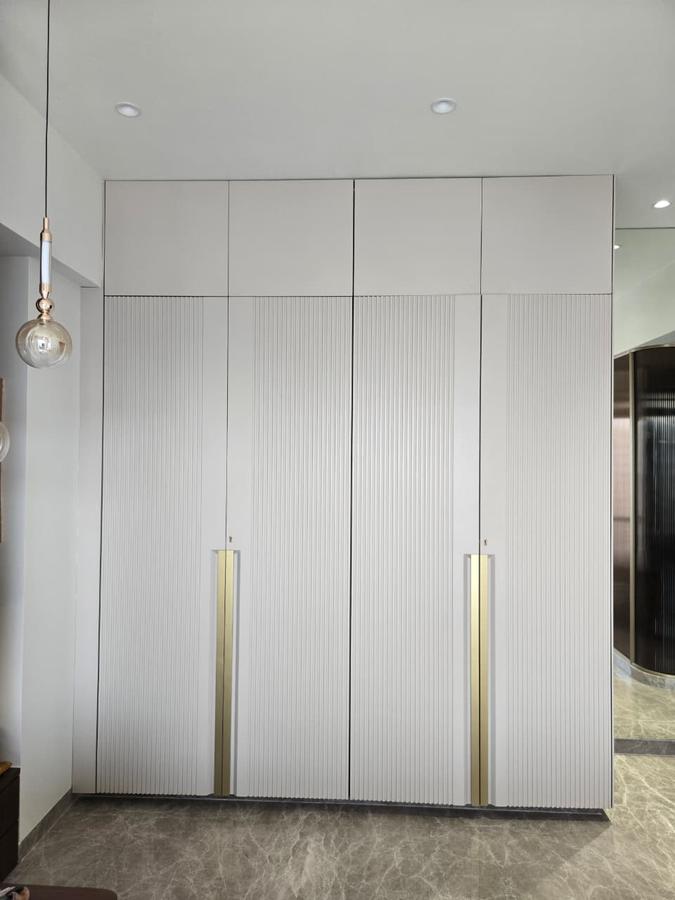 Beige fluted wardrobe with brass handles, styled bedroom