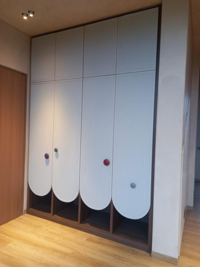 Scalloped white fluted wardrobe with colourful accent knobs