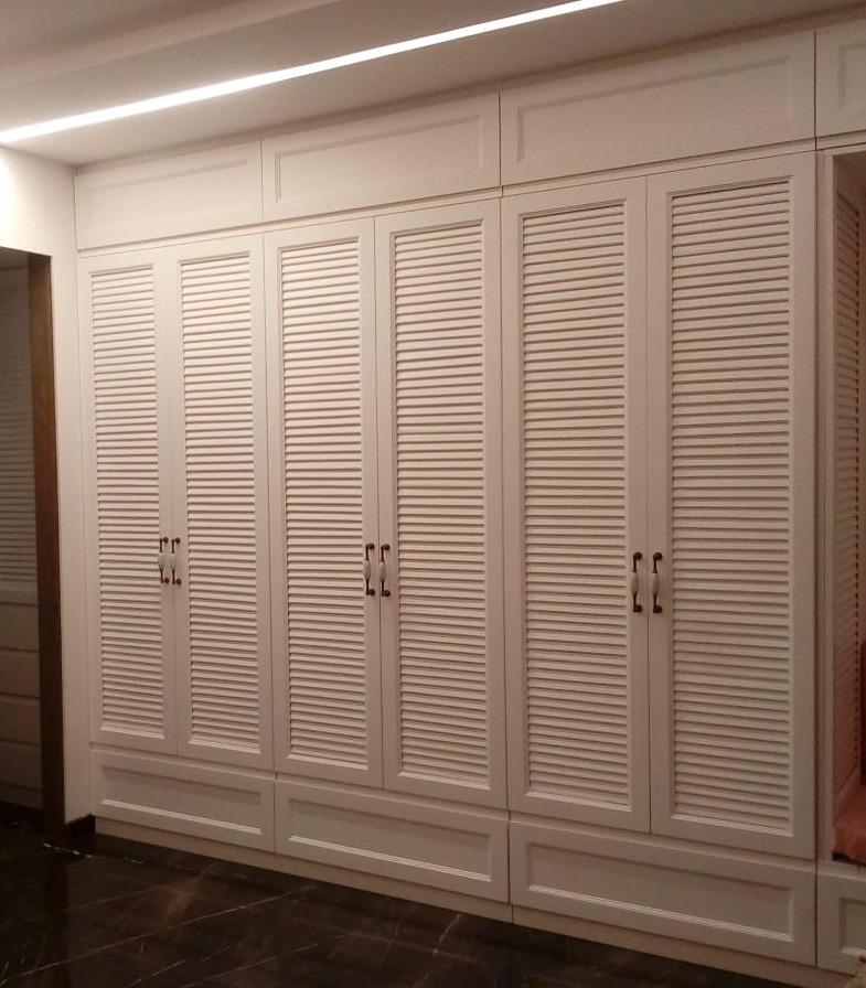 White louvered-panel wardrobe with vintage-style handles