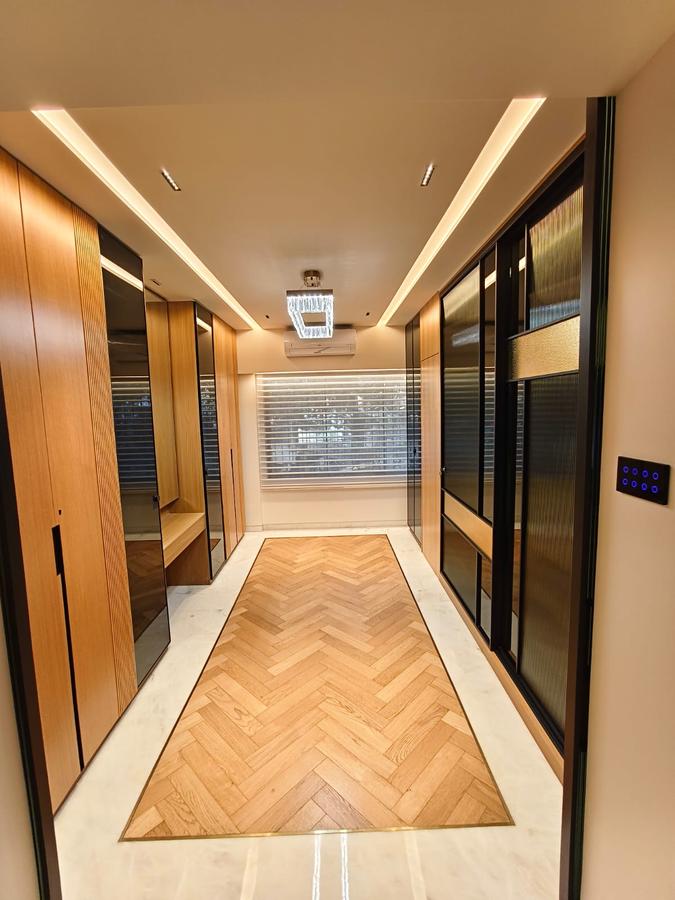Walk-in wardrobe corridor in walnut and smoked glass, herringbone floor