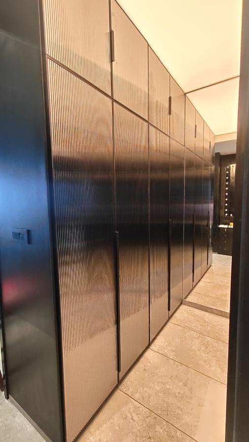 Bronze fluted wardrobe corridor with warm lighting
